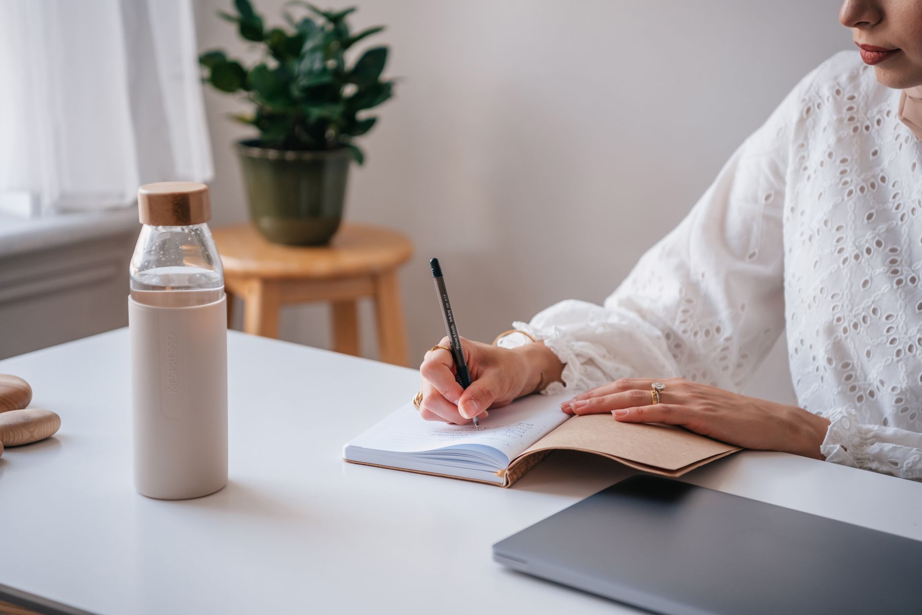 woman writing notebook water bottle